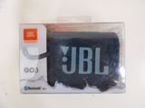 a black jbl speaker in a package on a table