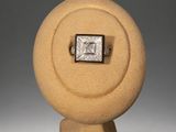an image of a diamond ring on a stand on a gray background