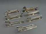 six pieces of silverware are arranged in a row on a gray surface