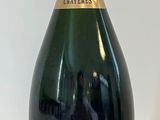 Des bouteilles de champagne sont alignées sur une surface blanche
