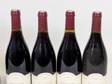 three bottles of red wine are lined up on a table
