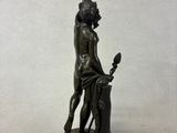 bronze statue of a man holding a bird on a pedestal