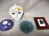 un masque blanc, un cadre photo et la photo d'une fleur posée sur une table