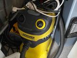 un aspirateur jaune et noir posé par terre à côté d'autres objets