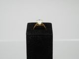 a close up of a gold ring with a white stone in it