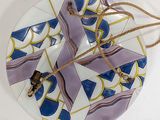 a white plate with a blue and purple design on it