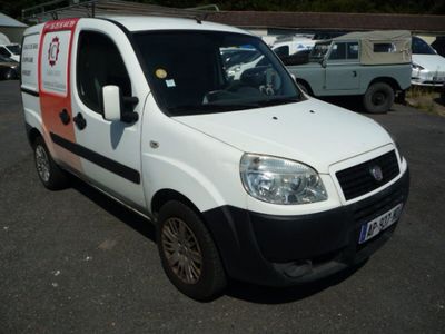 une petite camionnette blanche garée dans un parking