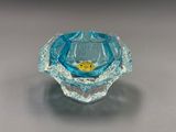 un gros plan d'un bougeoir en verre bleu posé sur une table