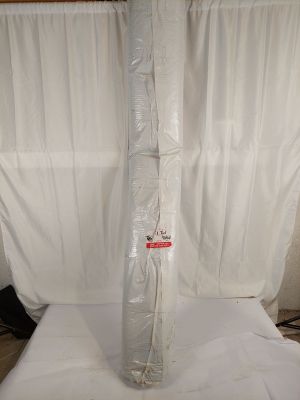un drap blanc emballé dans du plastique, posé sur un lit