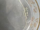 a silver bowl with gold writing on it sitting on a table