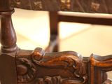 a close up of a wooden chair with a carved seat