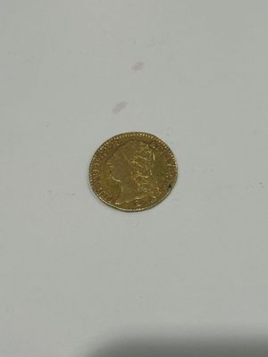 a close up of a gold coin on a white surface