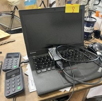 un ordinateur portable posé sur un bureau, à côté de télécommandes