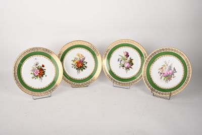 quatre assiettes ornées de motifs floraux, posées sur une surface blanche
