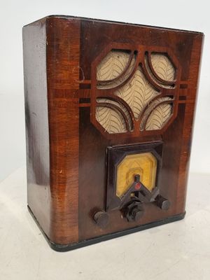 une radio à l'ancienne posée sur un meuble blanc