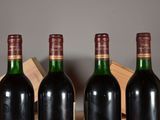 three bottles of wine sit in a wooden crate on a table