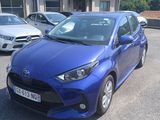 a blue toyota yaris parked in a parking lot