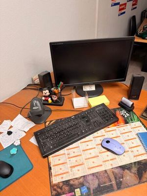 un bureau sur lequel se trouvent un ordinateur, un clavier, une souris et d'autres objets