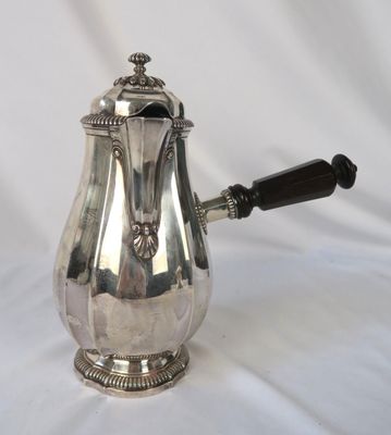 une cafetière ancienne en argent avec une poignée en bois sur fond blanc