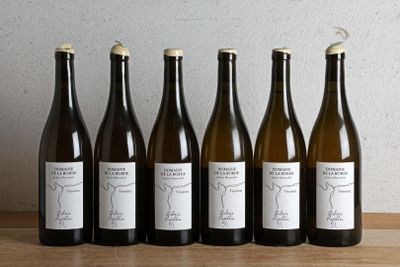 six bottles of wine sitting on top of a wooden table