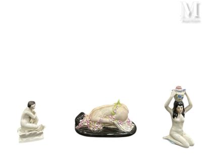 trois figurines représentant une femme et un homme assis par terre