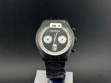 the watch is sitting on a metal stand on a black surface