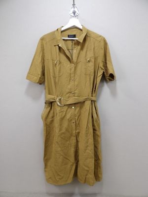 a brown shirt dress hanging on a wall next to a hanger