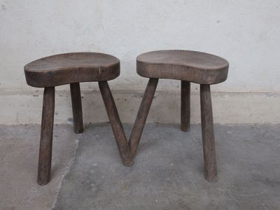 two wooden stools sitting next to each other in a room