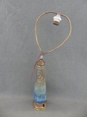 une petite bouteille en verre à laquelle est attaché un fil métallique