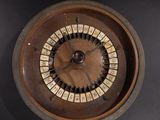 a wooden wheel with numbers on it on a black surface