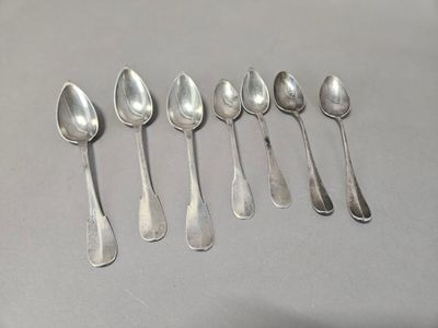 six silver spoons are lined up in a row on a table