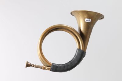 a brass instrument with a black handle on a white background
