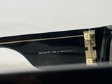 the sunglasses are black with gold trims on the sides of them