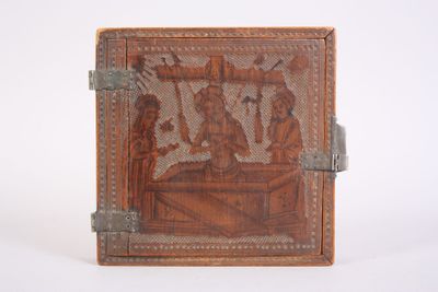 carvings on the back of a leather book with a silver handle