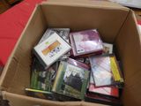 une boîte en carton remplie de DVD et de CD posée sur une table