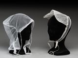 deux têtes de mannequin recouvertes de voiles blancs posées sur une tête de mannequin noire