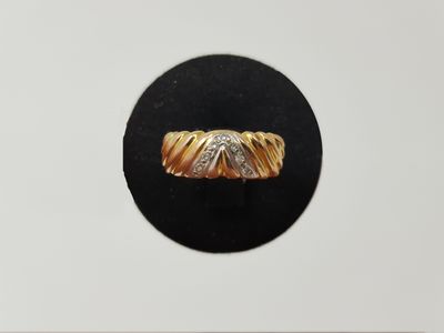 a close up of a gold and diamond ring on a black surface