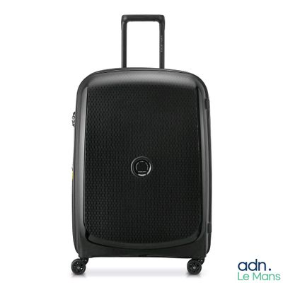 La valise noire repose sur ses roulettes, posée sur une surface blanche.