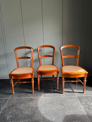 trois chaises placées les unes à côté des autres sur un sol carrelé