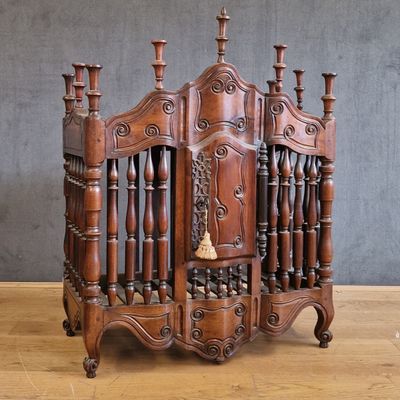 un berceau en bois surmonté d'une clochette