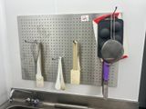 un évier de cuisine avec tout un tas d'ustensiles accrochés au mur