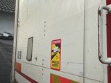 un camion blanc avec une bande rouge et jaune sur le côté