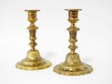 pair of antique brass candlesticks on a white background