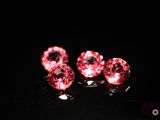 trois perles roses en cristal en forme de cœur sur un fond noir
