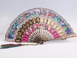 an image of a colorful fan with a tassel on a white surface