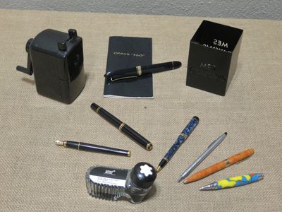 many different pens and pencils laid out on a table
