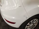 a close up of a white car with scratches on the side of it