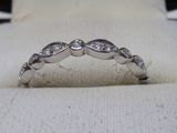 un gros plan d'une bague en diamant posée sur un tissu blanc
