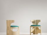 une paire de chaises dans une pièce blanche, avec un coussin bleu