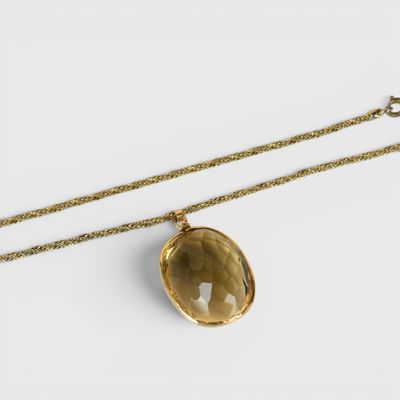 un collier en or orné d'une pierre de quartz jaune facettée, monté sur une chaîne en or